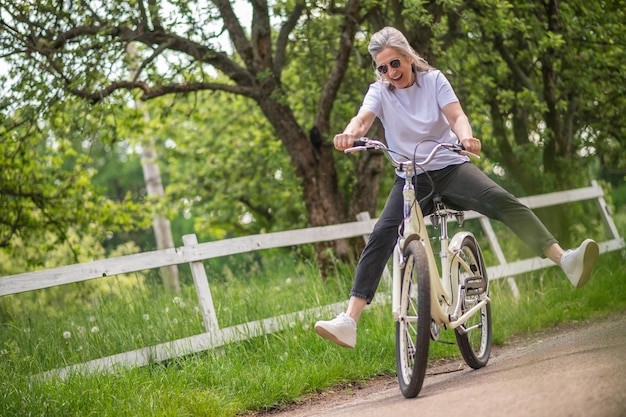 Balade dans un parc. Une femme faisant du vélo dans un parc et s'amusant