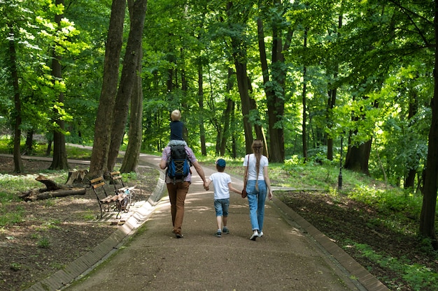 Balades en famille dans le parc. Maman, papa et deux enfants. Famille heureuse