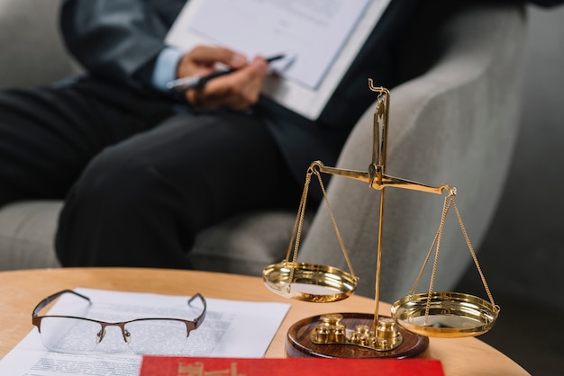 Balance de la justice devant un avocat désignant un contrat dans la salle d&#39;audience