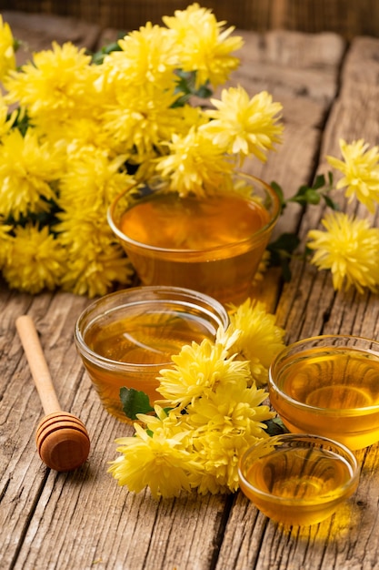 Balancier de miel et fleurs jaunes sur un fond de bois vieilli