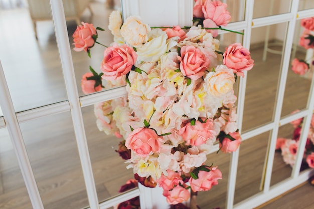 La balançoire en bois ornée de fleurs artificielles.