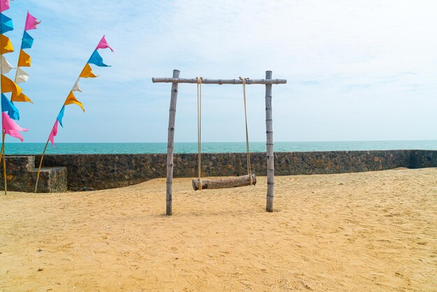 balançoire en bois sur la plage avec fond de mer