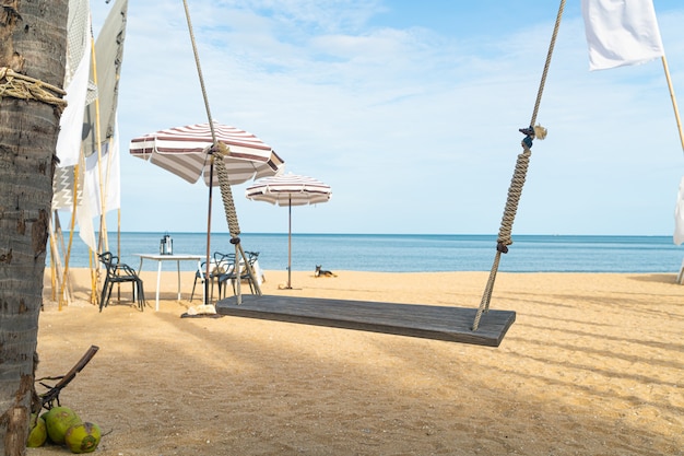 balançoire en bois sur la plage avec fond de plage de mer