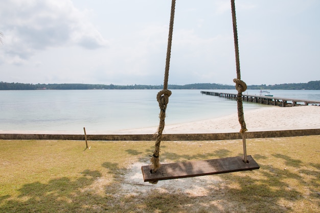 Photo balançoire en bois sur la plage