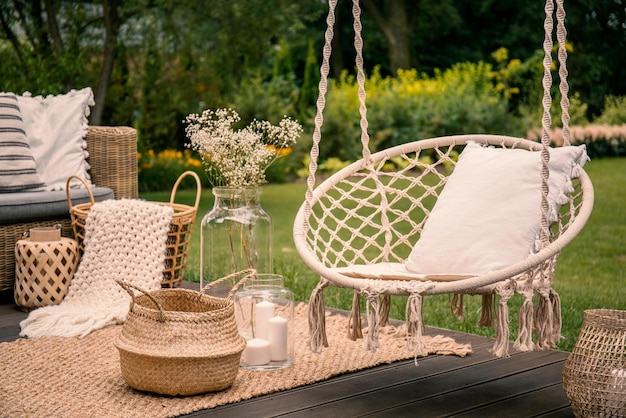 Une balançoire sur une terrasse avec un panier de fleurs