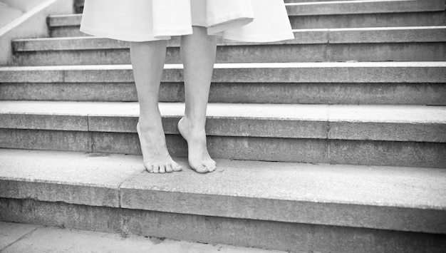 Balck et blanc jeune femme marchant pieds nus à l'extérieur.