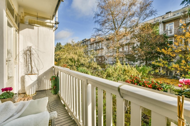 Un balcon avec une balustrade blanche et des plantes et des arbres