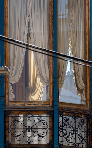 Balcon et fenêtre moderniste de Granollers avec son rideau joliment brodé dans une maison de Granollers