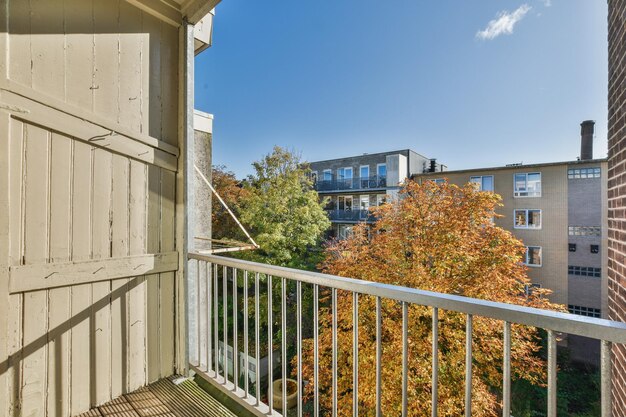 Un balcon avec vue sur un immeuble et des arbres