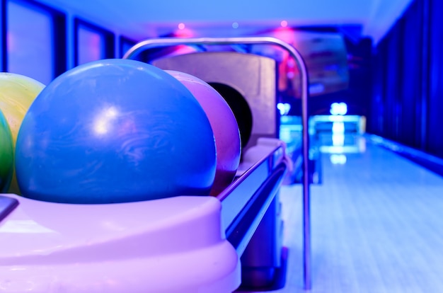 Photo une balle de bowling bleue est prête à être lancée par le joueur sur la piste en bois