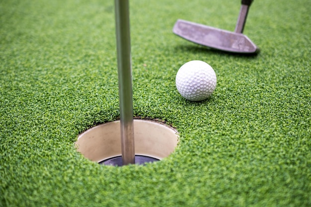 Balle de golf et club de golf sur gazon artificiel