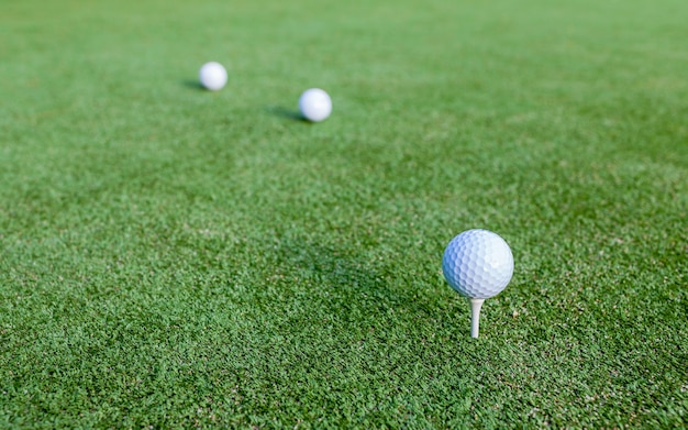 Balle de golf et tee sur l&#39;herbe verte pendant l&#39;entraînement au club de golf.