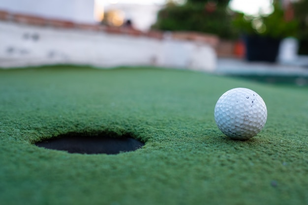 balle de golf et trou dans un terrain de minigolf