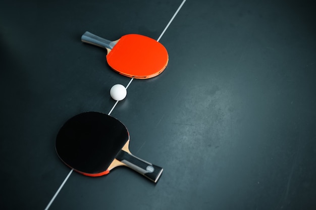 Photo balle de ping-pong et deux raquettes sur la ligne blanche, vue du dessus, personne, concept de tennis de table
