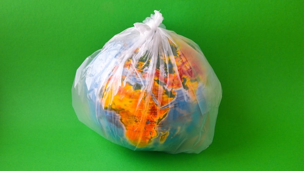 Balle sous la forme d'un globe est dans un sac en plastique en tant que concept de pollution plastique de la terre