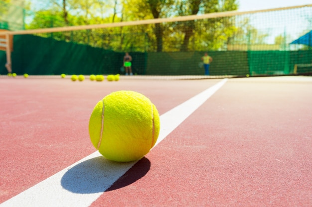 Balle de tennis sur un court de tennis avec filet