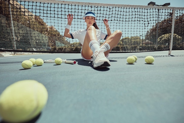 Balle de tennis femme et sport avec une fille contre le filet sur le terrain après l'exercice d'entraînement et d'entraînement pour la compétition en plein air Esthétique athlète et mode avec une femme sur un court de tennis pour le bien-être