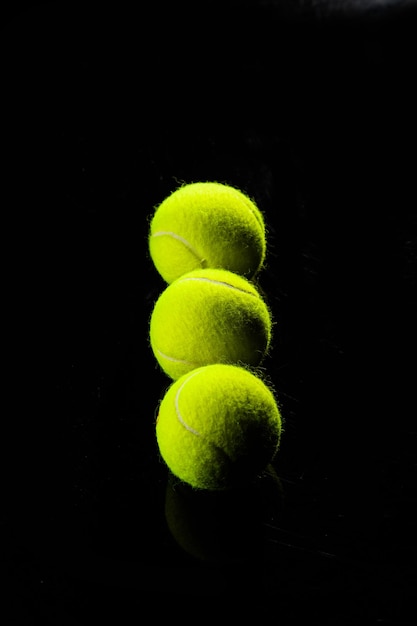 Balle de tennis isolée sur fond noir avec éclairage dramatique