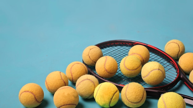 balle de tennis et raquette sur bleu