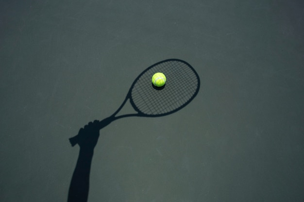 Balle de tennis avec raquette sur le court de tennis.