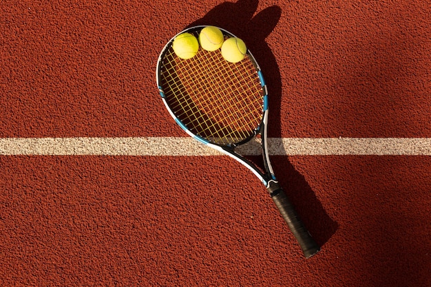 Balle de tennis avec raquette sur la raquette du court de tennis.