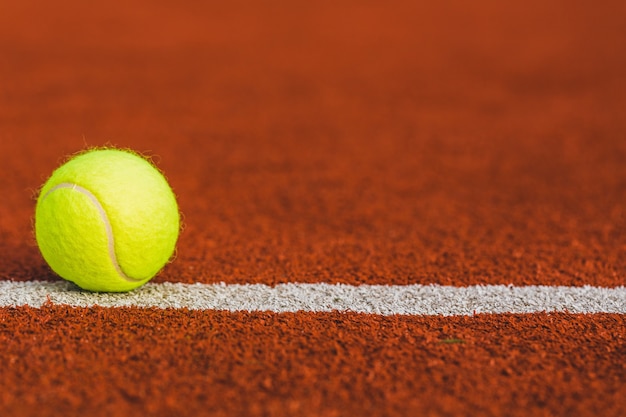 Balle de tennis sur le terrain en arrière-plan