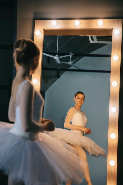 Ballerine élégante en robe blanche dansant en studio