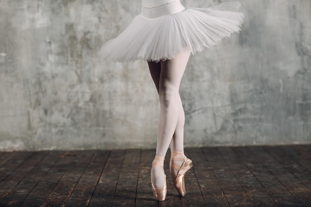 Ballerine femelle. Belle jeune femme danseuse de ballet, vêtue d'une tenue professionnelle, de chaussons de pointe et d'un tutu blanc.