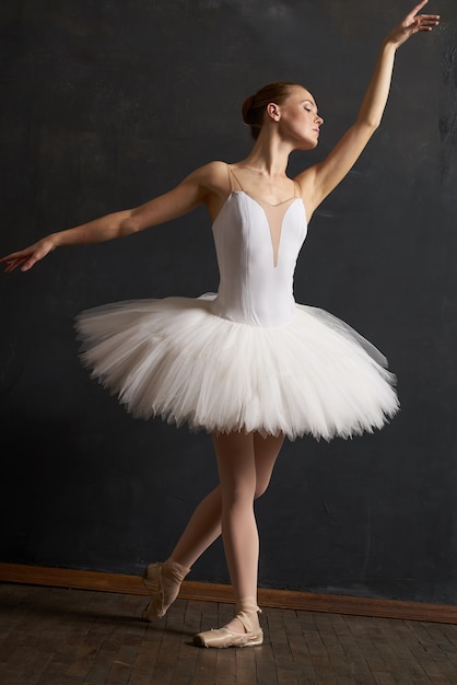 Ballerine de femme dans la danse de grâce de représentation de tutu blanc