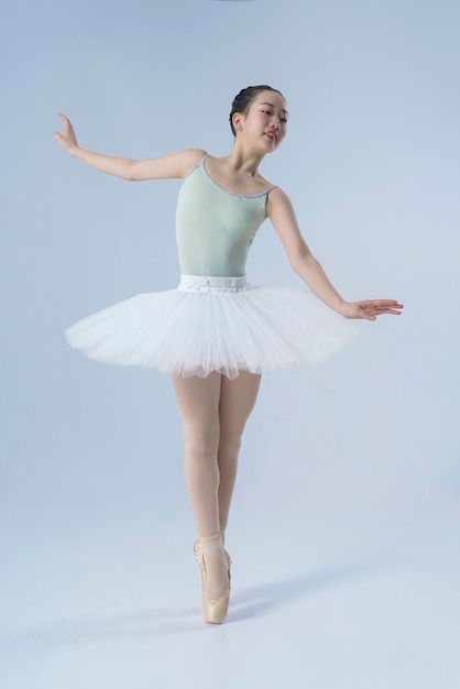 Photo une ballerine japonaise pose dans un studio photo avec des éléments de ballet montrant l'étirement et la plasticité