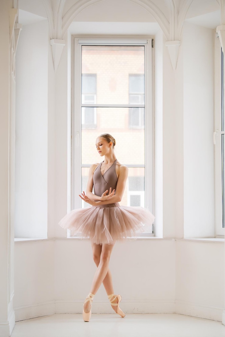 Photo une ballerine en maillot beige et tutu pose gracieusement en pointe dans un studio de ballet lumineux