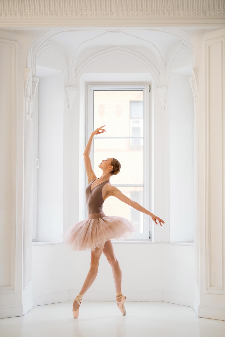 Photo une ballerine en maillot beige et tutu pose gracieusement en pointe dans un studio de ballet lumineux