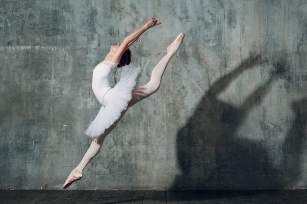 Ballerine sautante. Belle jeune femme danseuse de ballet, vêtue d'une tenue professionnelle, de pointes et de tutu blanc.