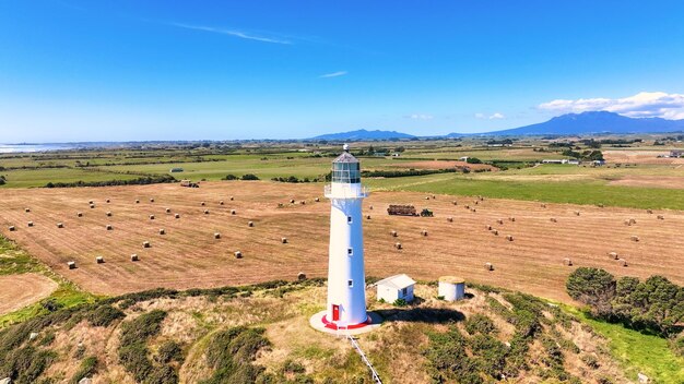 Des balles de foin et des machines agricoles sur des terres agricoles au phare de Cape Egmont à Taranakai