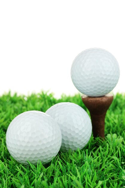 Balles de golf sur l'herbe isolées sur blanc
