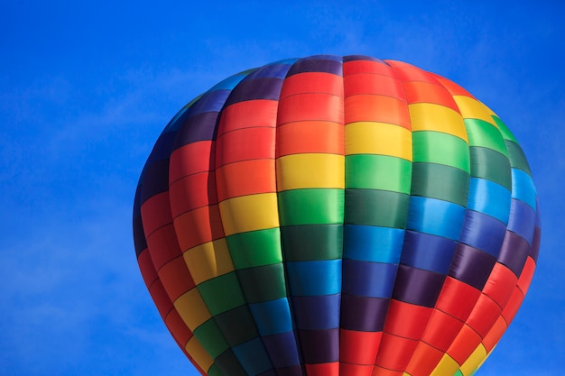 Ballon à air chaud arc-en-ciel avec ciel bleu