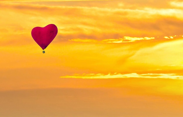 Photo un ballon à air chaud avec un cœur dans le ciel