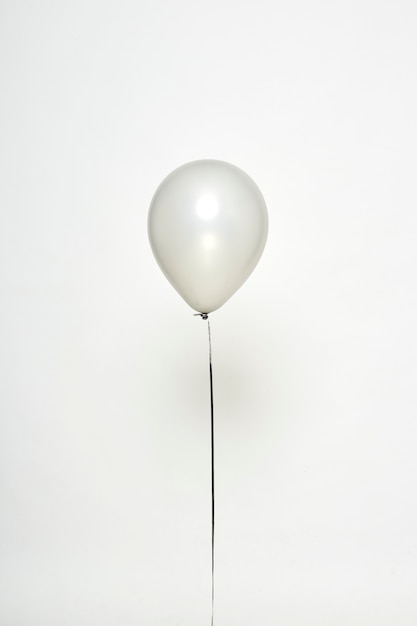 Photo ballon argenté flottant sur blanc