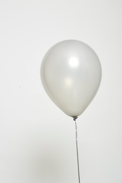 Ballon argenté flottant sur blanc