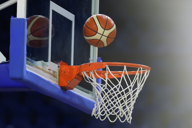 Un ballon de basket vole dans le ring. Sur le fond d'un complexe sportif