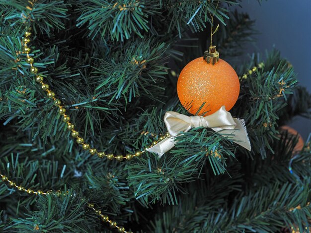 Ballon décoratif orange sur un arbre de Noël. Concept de nouvel an et de Noël