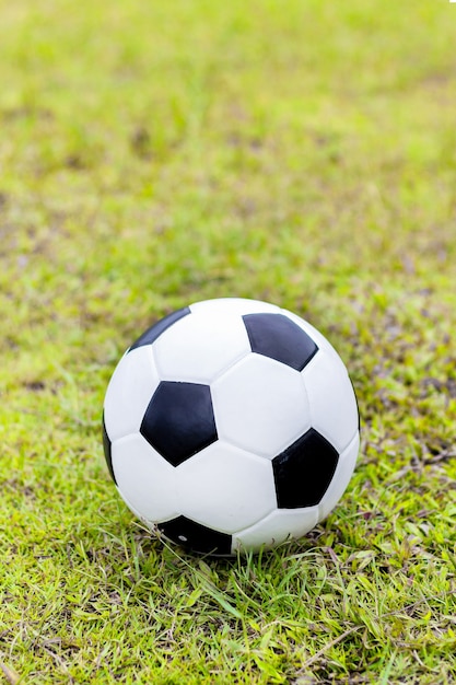 Ballon de foot sur l&#39;herbe verte avec flou artistique et sur fond de lumière