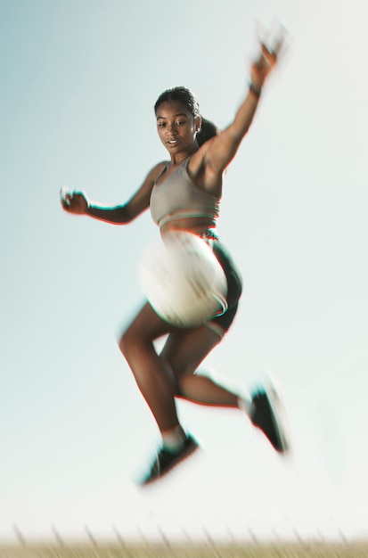 Ballon de football et athlète sautant pour un tour pendant l'entraînement pour un match sur un terrain de sport en plein air Football fitness et femme avec des compétences sportives et de l'énergie pratiquant avec motivation et exercice