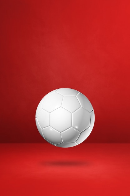 Photo ballon de football blanc isolé sur fond de studio rouge. illustration 3d