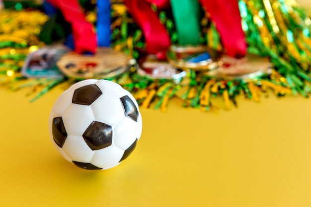 Ballon de football de coupe du monde et médailles sur le fond jaune
