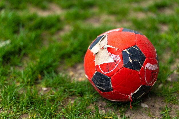 Un ballon de football déchiré se trouve sur l'herbe
