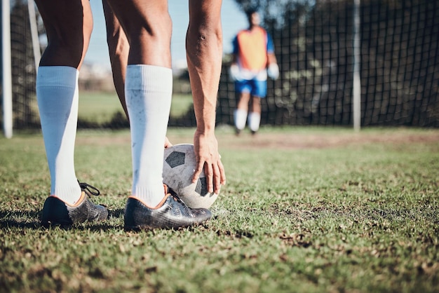 Photo le ballon de football est un sport et les pieds d'une personne pour frapper sur le terrain, s'entraîner ou tirer pour un but dans le filet. le joueur de football et les jambes de l'athlète dans une compétition d'exercice ou un défi sportif pour des buts.