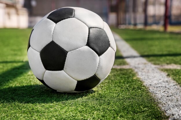 Ballon de football sur l'herbe verte fraîche à l'extérieur