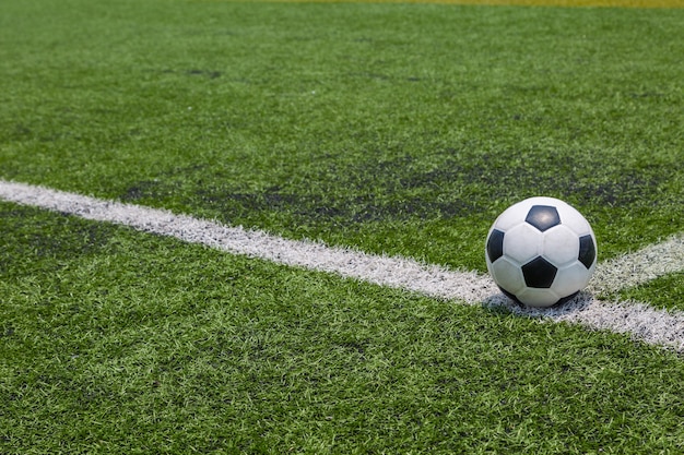 ballon de football sur la ligne blanche sur fond d&#39;herbe de terrain de football vert