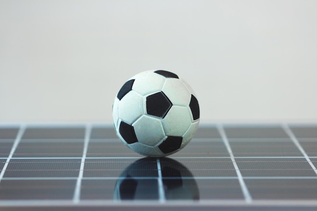 Ballon de football sur panneau solaire photovoltaïque isolé Image concept sport et technologie